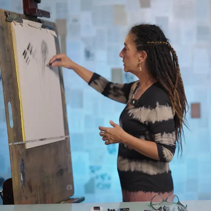 Elli standing at her easel, drawing
